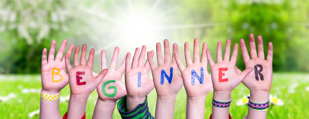 Children Hands Building Colorful English Word Beginner. Sunny Green Grass Meadow As Background