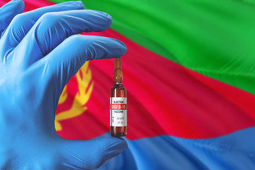 Eritrea flag with Coronavirus Covid-19 concept. Doctor with blue protection medical gloves holding...