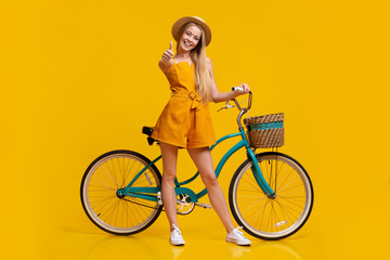 Fototapeta na wymiar Eco Transport. Girl Standing Next To Vintage Bike And Showing Thumb Up
