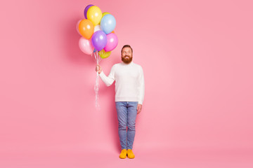Full size photo candid imposing guy hold many air balloons wait birthday party celebration look copyspace feel curious wear knitted sweater sneakers isolated pastel color background