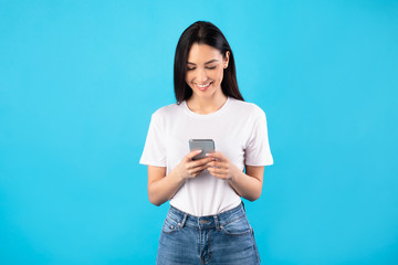 Happy girl using mobile phone at studio