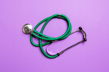 Top view of green stethoscope on colorful background. Medical diagnosis tool concept