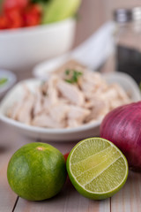Half cut lemons and red onions placed on a wooden table.