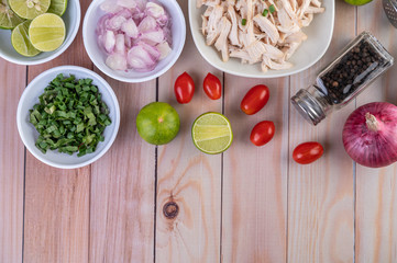 Boiled chicken cut into pieces in a white dish on a wooden table.
