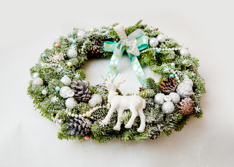 Christmas wreath with cones, Christmas toys, sprinkled with artificial snow, decorated with ribbons...