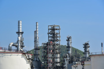Oil refinery plant from industry, Refinery Oil storage tank and pipe line steel with blue sky background.
