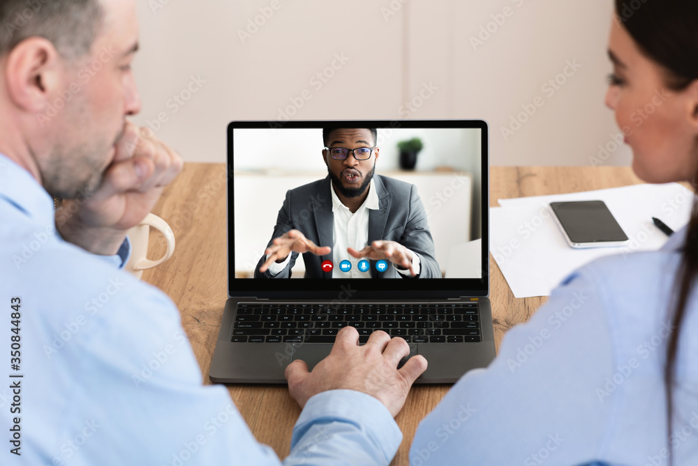 Wall mural workers having discussion during video call with colleague