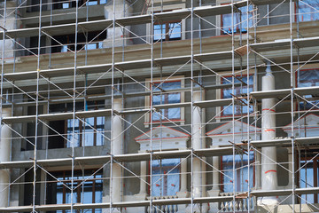 scaffolding at the facade of a building under construction, multi-storey building, without people