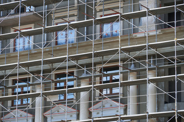 scaffolding at the facade of a building under construction, multi-storey building, without people