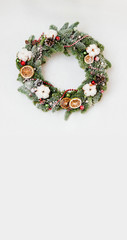 Christmas wreath with red shiny beads with flowers of cotton and slices of dried oranges