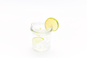 tonic jar with ice and a slice of lemon on a white background