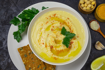 chickpeas hummus with olive oil on a black background