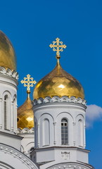 Gilded dome of the Orthodox Church against the blue sky with clouds in summer closeup