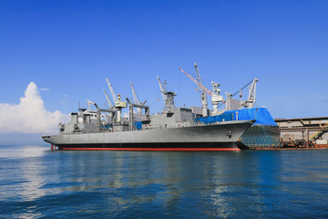 Fototapeta premium The ship in shipyard during maintenance, alongside near floating dock yard.
