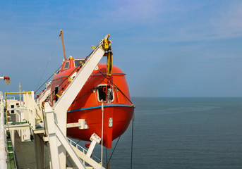 Closed lifeboat in tanker ship at starboard side.Davit systems for used to lower an emergency lifeboat to the embarkation level to be boarded.