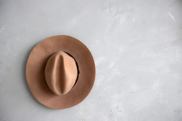 beige hat Fedora on the gray wall.