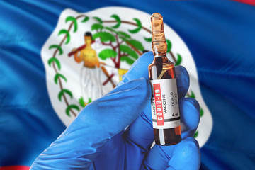Belize flag with Coronavirus Covid-19 concept. Doctor with blue protection medical gloves holds a...