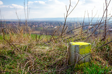 A little concrete pillar on the grass and city in the distance