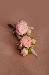 Wedding boutonniere of live roses on a background of brown kraft paper