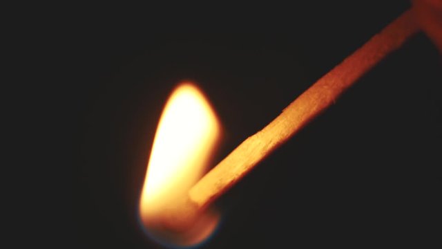 burning match and beautiful smoke from it on a dark background in slow motion