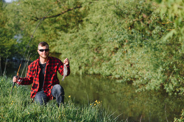 Man relaxing and fishing by lakeside. Weekends made for fishing. Fisher masculine hobby. Master baiter. Keep calm and fish on. Fishman crocheted spin into the river waiting big fish. Guy fly fishing