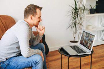 Video call with a group of people. A guy is using laptop for talking online with a several people...