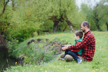Naklejka na ściany i meble Father and son fishing together