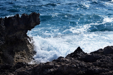 The rocky, steep shore. Beautiful view of the stormy restless sea. Tidal hole