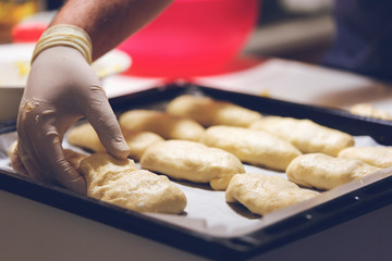 Chef working with dough in bakery. Cooking fancy bread, making delicious pastry on homemade recipe