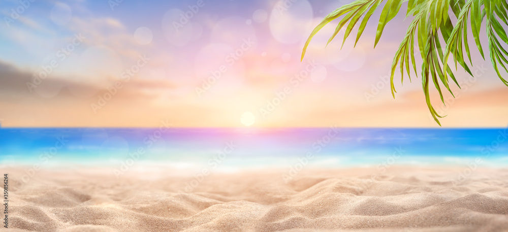 Poster A summer vacation, holiday background of a tropical beach and blue sea at sunset with the sun on the horizon with bokeh and palm trees.