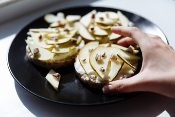 Hand is holding homemade fruit cake for breakfast on the ceramic plate. Top view. selective Focus