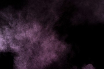 Purple powder explosion on black background. Colored powder cloud. Colorful dust explode. Paint Holi.