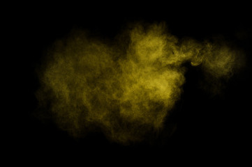 Yellow powder explosion on black background. Colored powder cloud. Colorful dust explode. Paint  Holi.