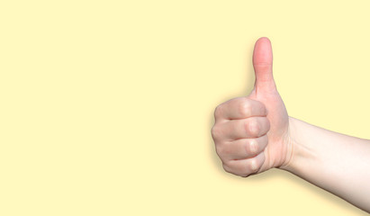 mano de persona realizando un gesto de aprobacion haciendo el simbolo like con los dedos sobre un fondo amarillo