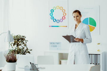 Dietician holding notes and standing in her office