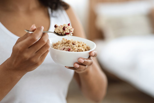 Healthy Meal Concept. Unrecognizable black woman eating oatmeal with fruits for breakfast