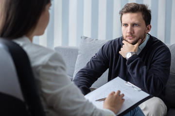 Confident young handsome man during last psychotherapist session with counselor