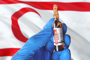 Northern Cyprus flag with Coronavirus Covid-19 concept. Doctor with blue protection medical gloves holds a vaccine bottle. coronavirus covid 19 vaccine research.