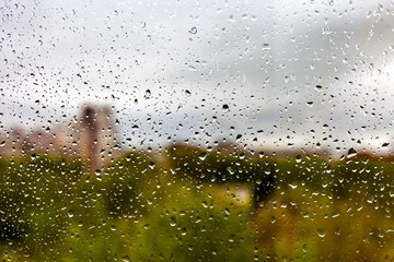 Drops of water on the window glass after the rain on the background of the city