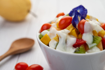 Fruit salad in a bowl on the wooden floor.