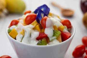 Fruit salad in a bowl on the wooden floor.
