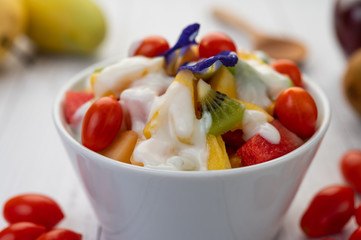 Fruit salad in a bowl on the wooden floor.