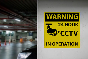 Warning sign "WARNING 24 HOUR CCTV IN OPERATION" installed on the parking lot to protection security.