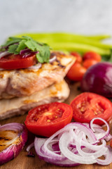 Chicken steak placed on a wooden tray.