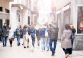 People walking at city centre, blurred, defocused picture. Pedestrians in Italian street in Verona, Italy. Unrecognizable people, tourists in small town. 