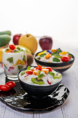 Fruit salad in a bowl on the wooden floor.