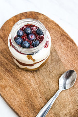 Healthy cheesecake in a mason jar and on top of a wooden board. Food styling & food photography for the culinary blog.