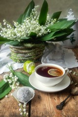Cup of tea with lime and lily of the valley
