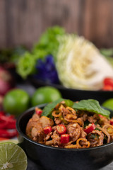 Spicy pork chops in a black cup consisting of lemons Chili and side dishes