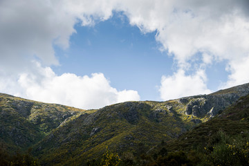 Obraz na płótnie Canvas Mountain hill under blue cloudy skies